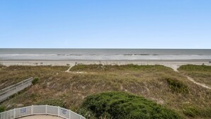 Une vue sur la plage avec une promenade en bois menant au rivage.