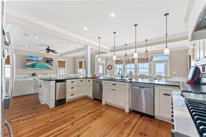 A spacious kitchen with a central island, white cabinetry, and a large island dishwasher. - Diamond in the Ruff - Total Luxury 8BR OF Home (North Myrtle Beach)
