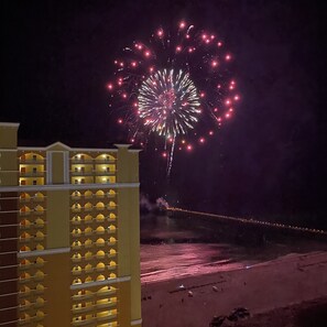 A hotel with multiple balconies and a view of fireworks in the background. - Barefoot at Calypso III, handicap, 4/4 + bunks (Panama City Beach)