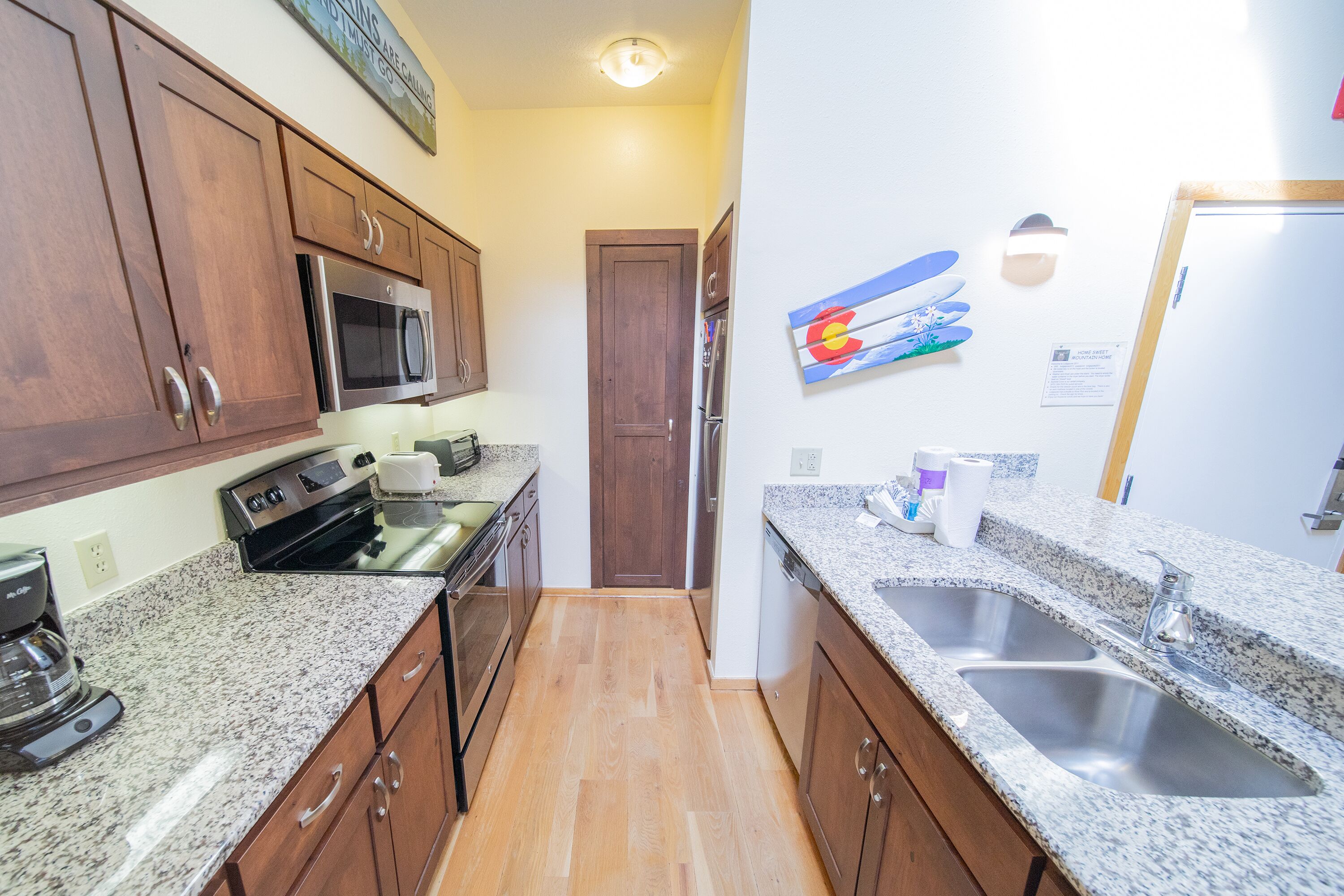 A kitchen with granite countertops, stainless steel appliances, and wooden cabinets.