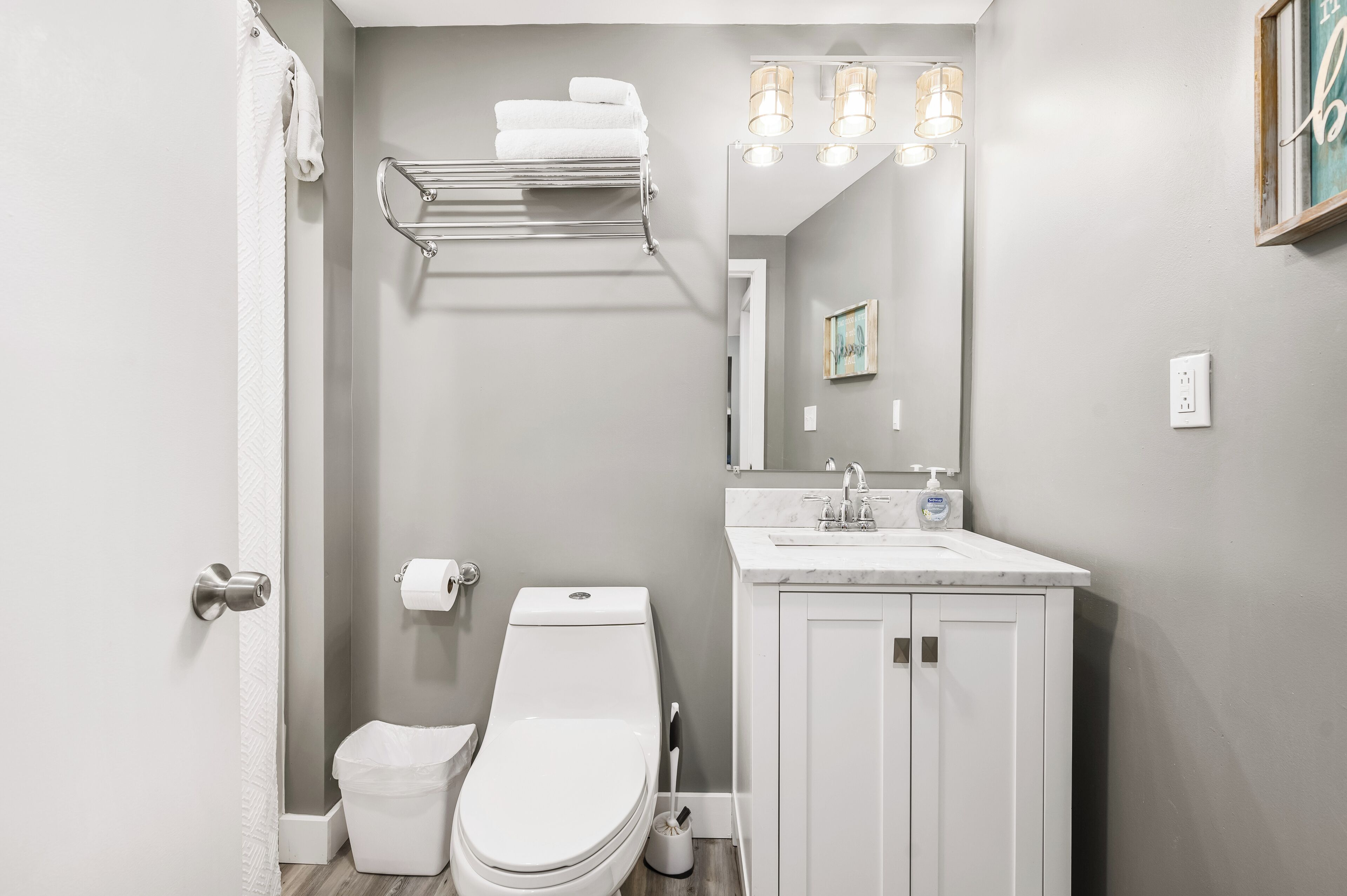 A modern bathroom with a toilet, sink, and towel rack.