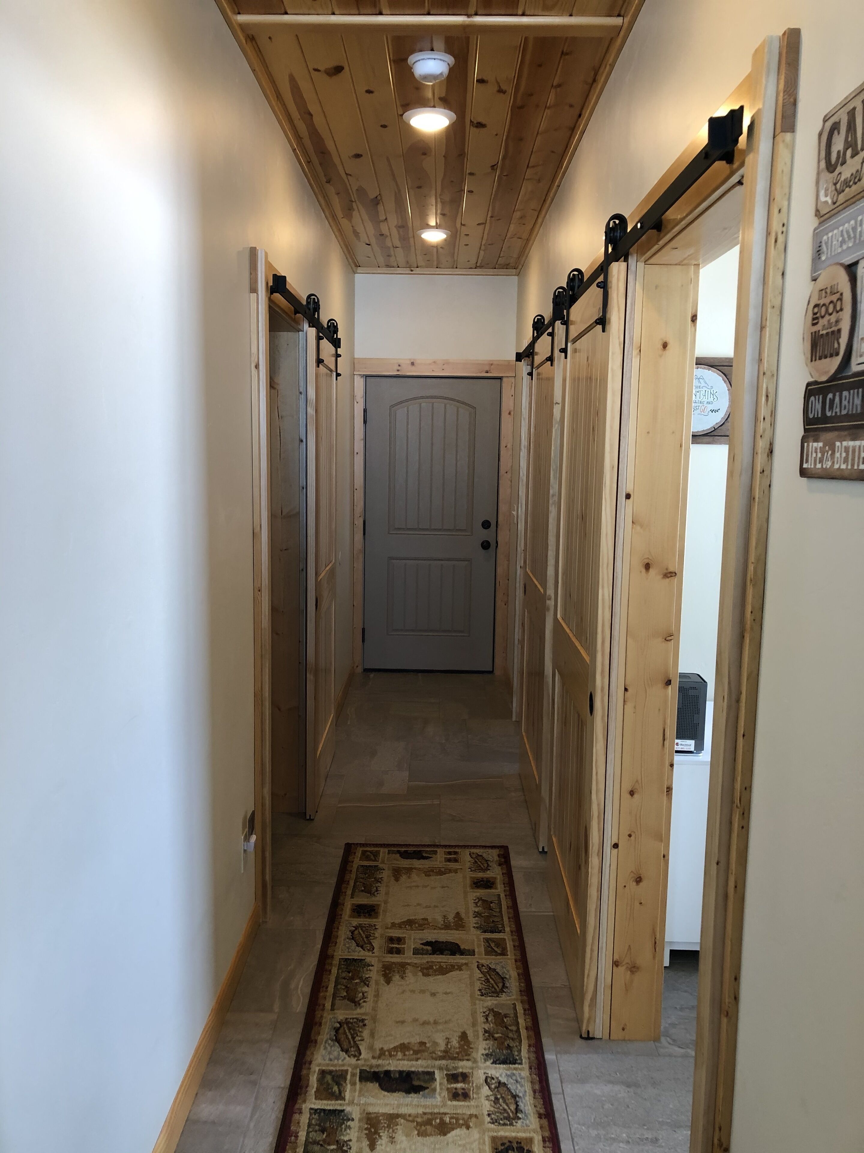 A narrow hallway with wooden walls and a door at the end.