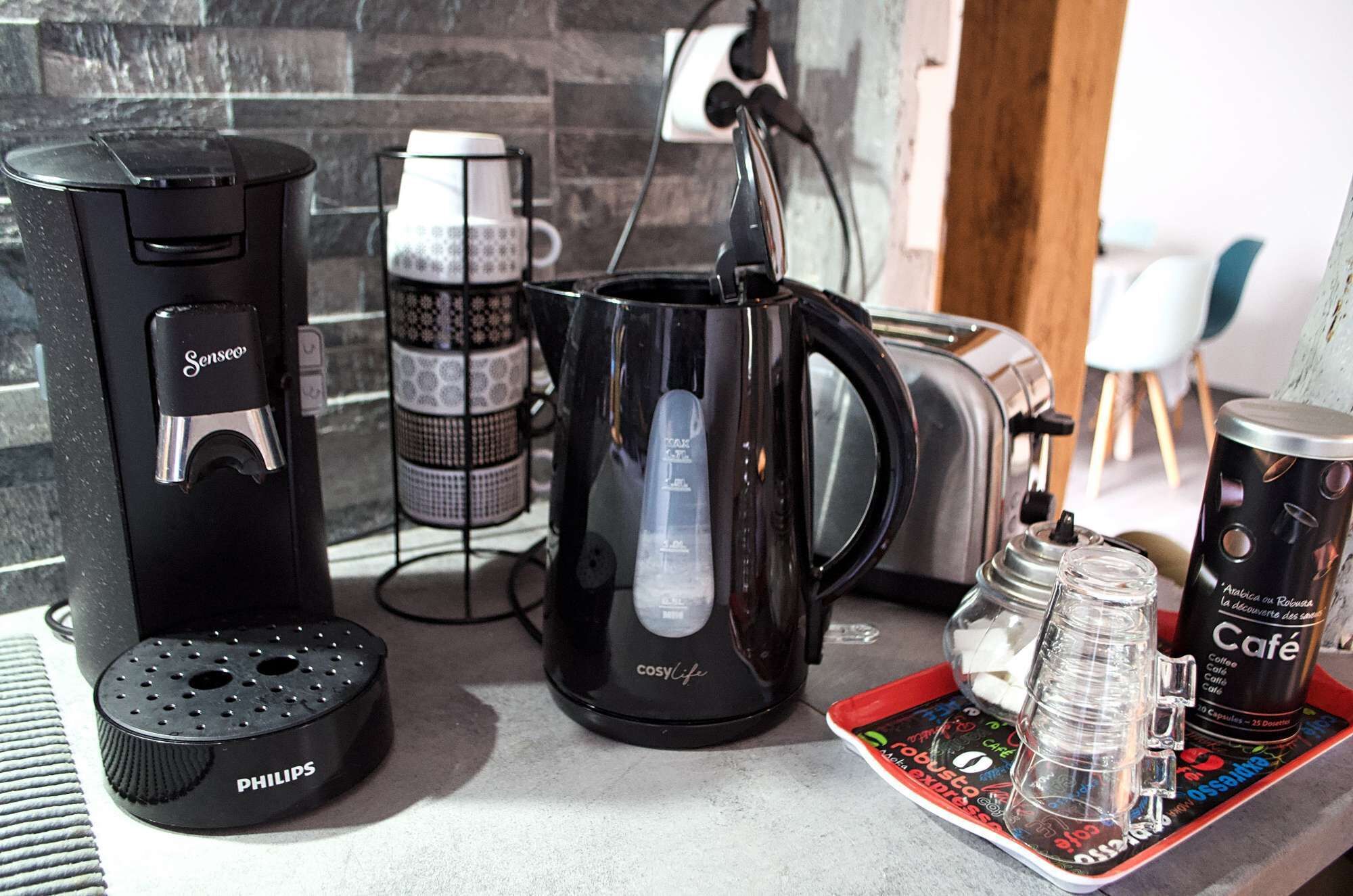 Eine Küchenarbeitsplatte mit Kaffeemaschine, Wasserkocher, Toaster und einer Kaffeetasse.