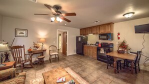 A spacious living room with a wooden coffee table, a fireplace, and a dining area with a wooden table and chairs.