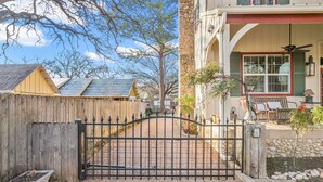 A gated entrance with a wooden fence, a stone wall, and a bench with a table. - Charming Private 2-Story Cottage - Romantic Getaway - Close to Downtown (Fredericksburg)