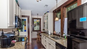A kitchen with granite countertops, stainless steel appliances, and wooden cabinets.