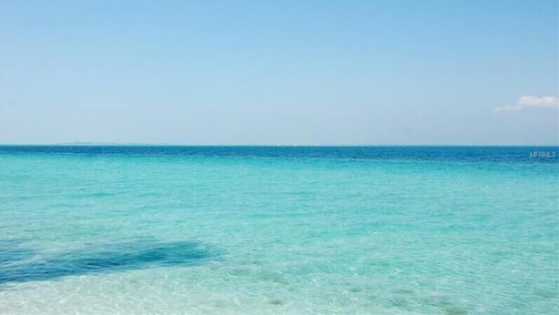 On peut admirer une eau océanique d’un bleu turquoise éclatant sous un ciel dégagé.