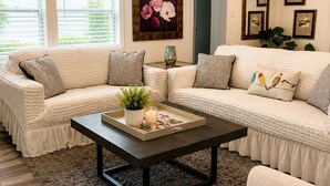 A living room with a sectional sofa, a coffee table, and a painting on the wall.