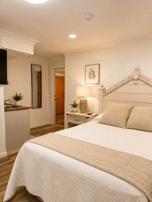 A bedroom with a bed, bedside table, lamp, and a framed picture on the wall. - Mangroves at Bayhouse and Bungalows of FH (Fairhope)