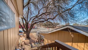 A wooden deck with a view of a tree and a street. - harming Downtown Fredericksburg Retreat – Cozy, Walkable, & Vintage (Fredericksburg)