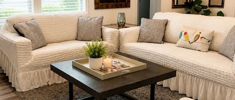 A living room with a sectional sofa, a coffee table, and a painting on the wall.