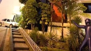 A tall building with a red and white facade, surrounded by greenery and a staircase leading up to the entrance. - Rede Andrade LG Inn Recife (Recife)