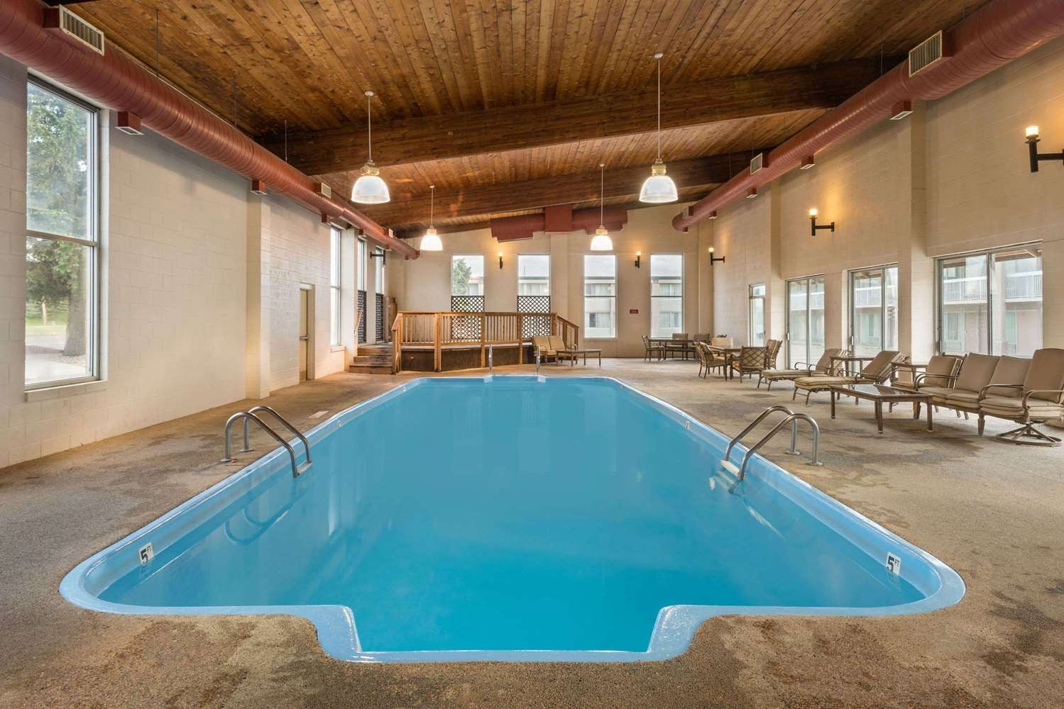 A swimming pool with a wooden ceiling and seating area.