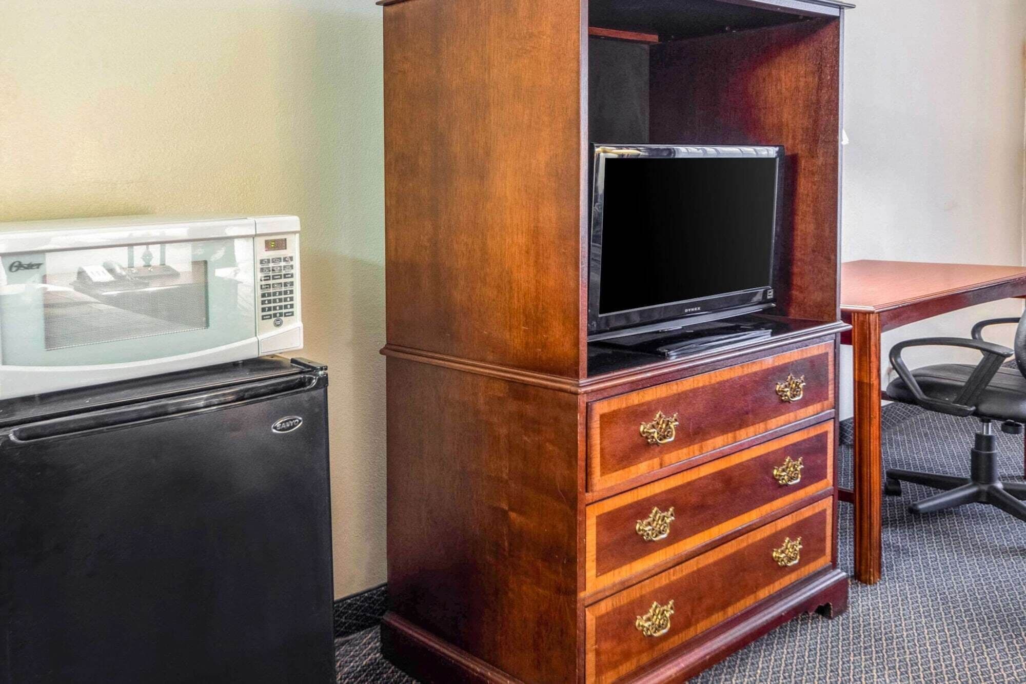 A minibar with a microwave, a television, and a refrigerator.