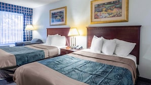 A hotel room with two beds, a desk, and a chair. There are two framed pictures on the wall. - Heritage Inn & Suites by Capital O Baton Rouge I 10 (Baton Rouge)