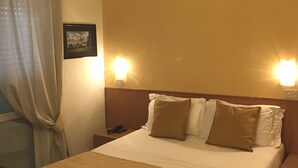 A hotel room with a bed, two bedside tables, a nightstand, a lamp, and a picture on the wall. - hotel villa fernanda  (Massa Lubrense)