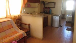A compact living space with a kitchenette, a dining area, and a small bathroom.