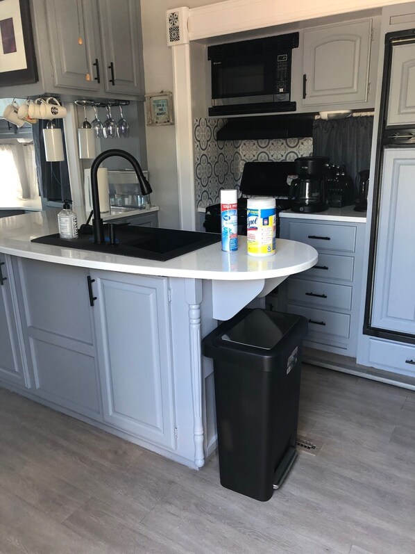 Kitchen features a sink, microwave, and coffee maker.