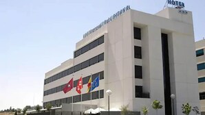 A modern hotel building with multiple floors, a prominent "HOTEL" sign on the top, and several flags displayed outside. - Eco Via Lusitana (Madrid)