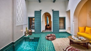 Un pati amb piscina, sofà i taula de dinar.