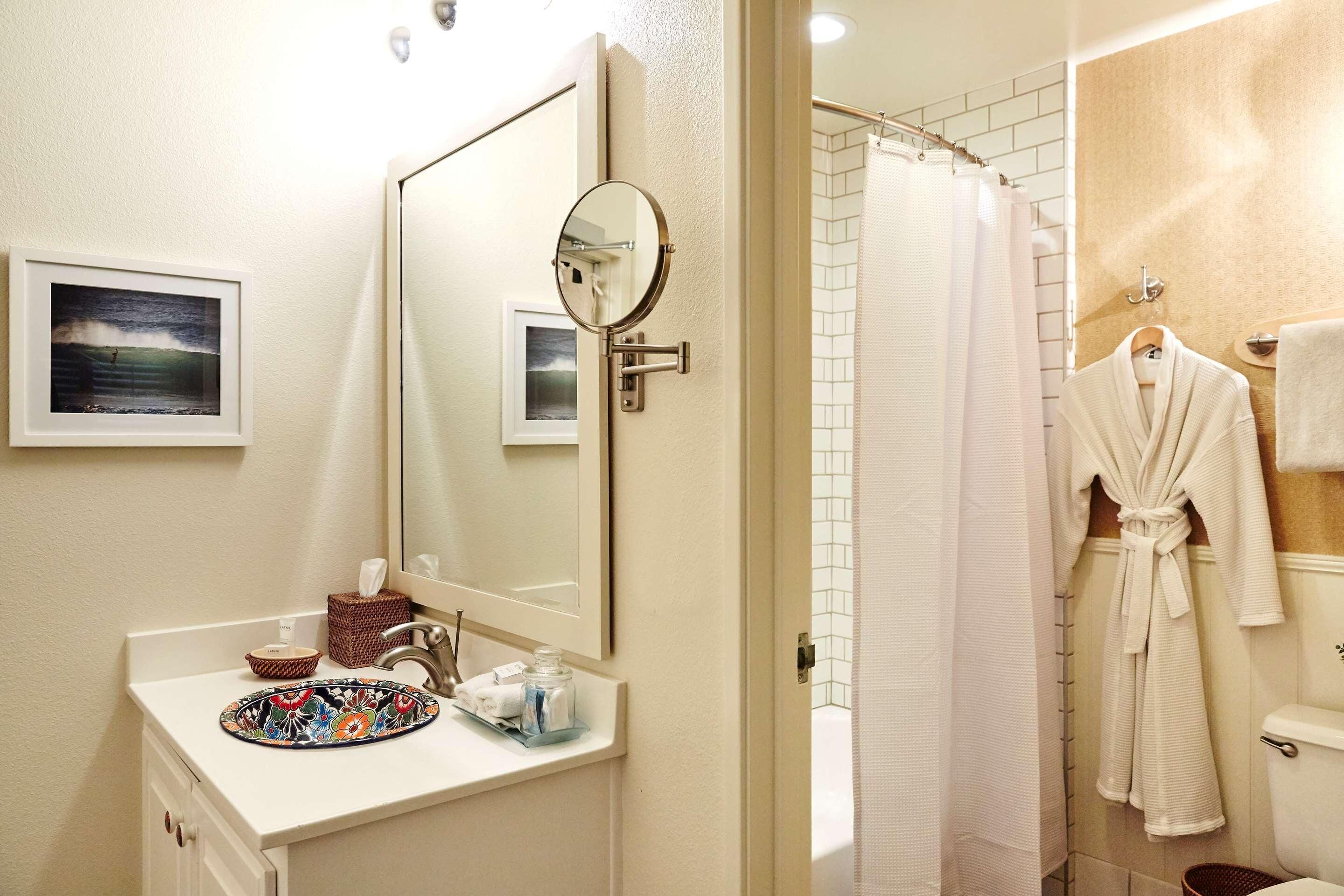 A bathroom with a sink, mirror, and towel rack.