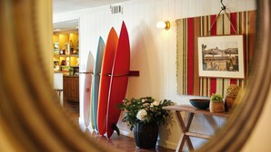 A room with surfboards leaning against the wall, a potted plant, and a framed picture on the wall. - Laguna Beach House (Laguna Beach)