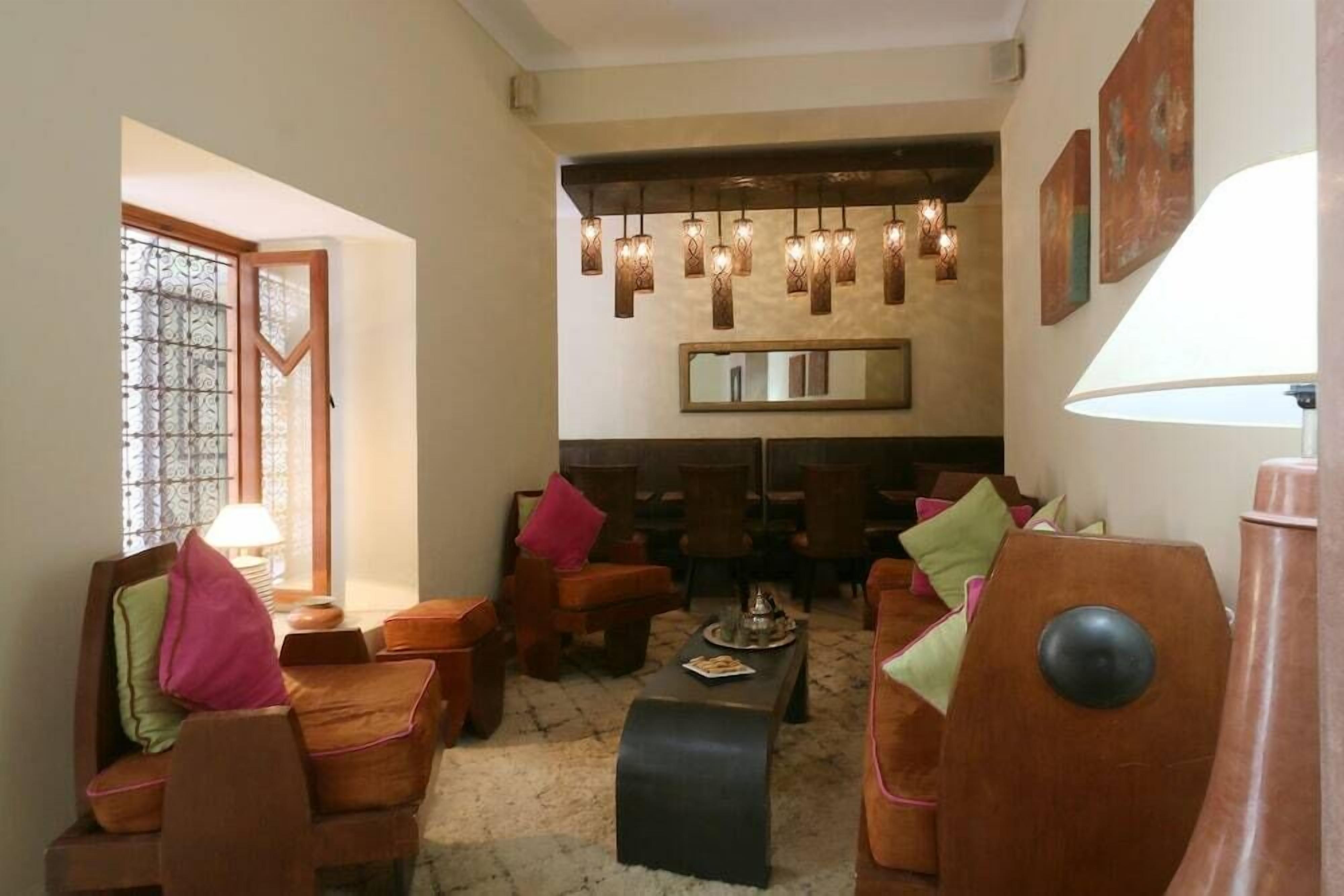 Un salon chaleureux avec des meubles en bois, une table basse et des lampes suspendues.