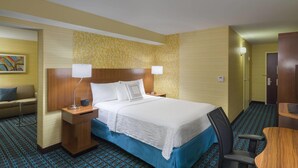 A hotel room with a bed, two bedside tables, a desk, a chair, and a couch. - Fairfield Inn Suites By Marriott Paramus (Paramus)
