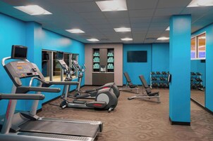 Un gimnasio con cintas de correr, elípticas y bancos de pesas.