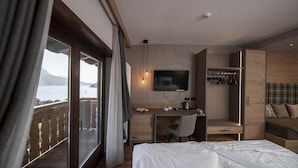 Une chambre d’hôtel équipée d’un lit, d’un bureau, d’une télévision et d’une armoire.