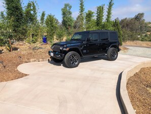 A black Jeep Rubicon SUV parked on a driveway.