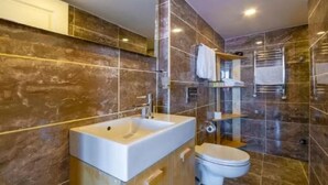 A modern bathroom with a large sink, toilet, and shower area. - Hotel Next2 (Istanbul)