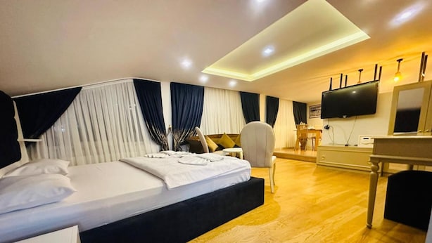 A modern hotel room with a large bed, a desk, a chair, and a flat-screen TV. - Hotel Next2 (Istanbul)