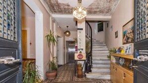 A hallway with patterned flooring, a staircase, and a chandelier. - Hotel Next2 (Istanbul)