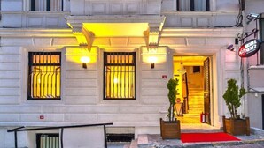 A hotel entrance with a red carpet, illuminated entrance, and a sign indicating the hotel name. - Hotel Next2 (Istanbul)