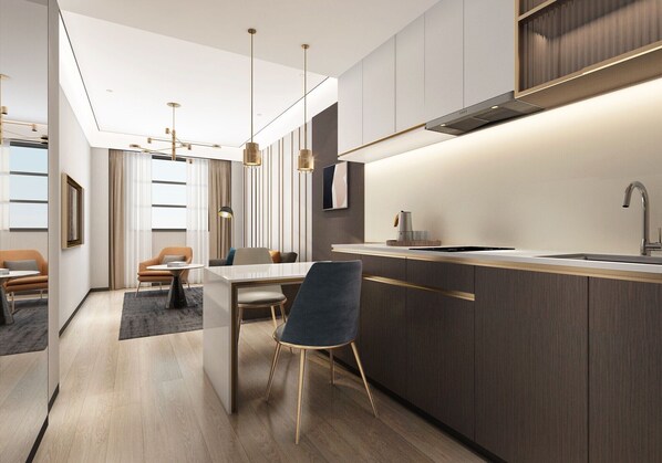 Une cuisine moderne dotée d’un îlot central, de luminaires suspendus et d’un coin repas avec un canapé et des chaises.