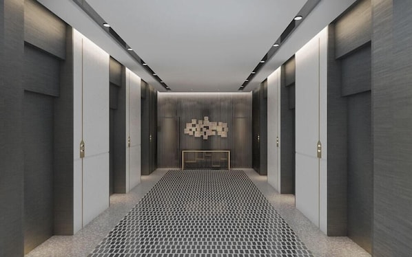 Un couloir moderne avec un sol à motifs, un éclairage encastré et un mur décoratif central.