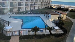 Et hotel med swimmingpool, udesidning og udsigt til stranden.