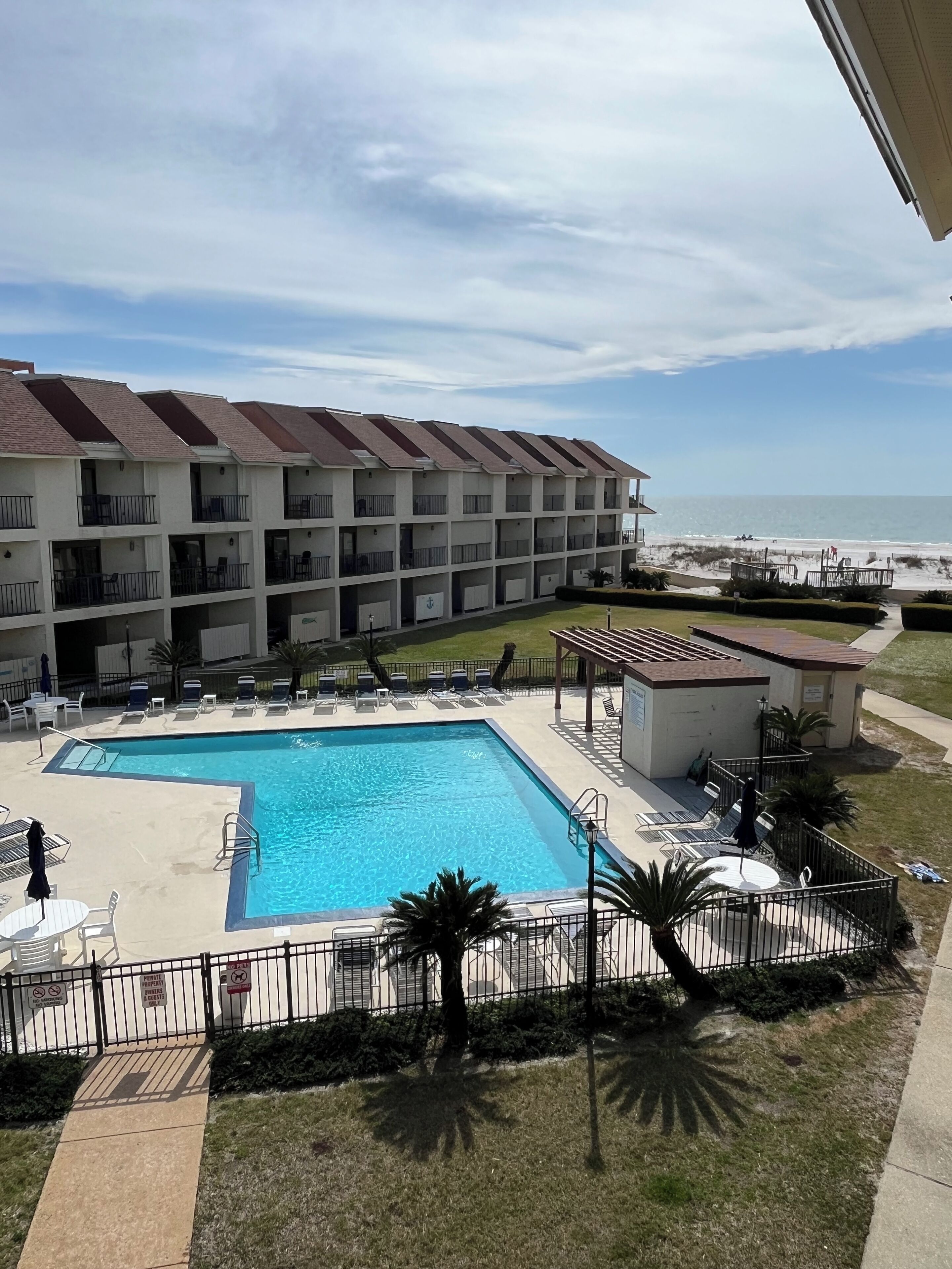 Un hotel con piscina, mobiliario exterior y vistas a la playa.