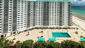 Ein Hochhaus-Hotel mit Poolbereich und Blick auf den Strand.