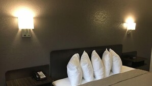 Ein Hotelzimmer mit einem Bett, zwei Nachttischen und zwei Wandleuchten.