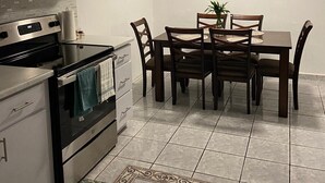 A modern kitchen with a dining area, featuring a stove, oven, cabinets, and a dining table with chairs. - La Casita Verde in Cupey - Villa with Pool-Hot Tub and POWER GENERATOR (San Juan)