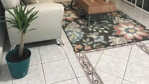 A living room with a sofa, a coffee table, two chairs, a potted plant, and a bookshelf. - La Casita Verde in Cupey - Villa with Pool-Hot Tub and POWER GENERATOR (San Juan)