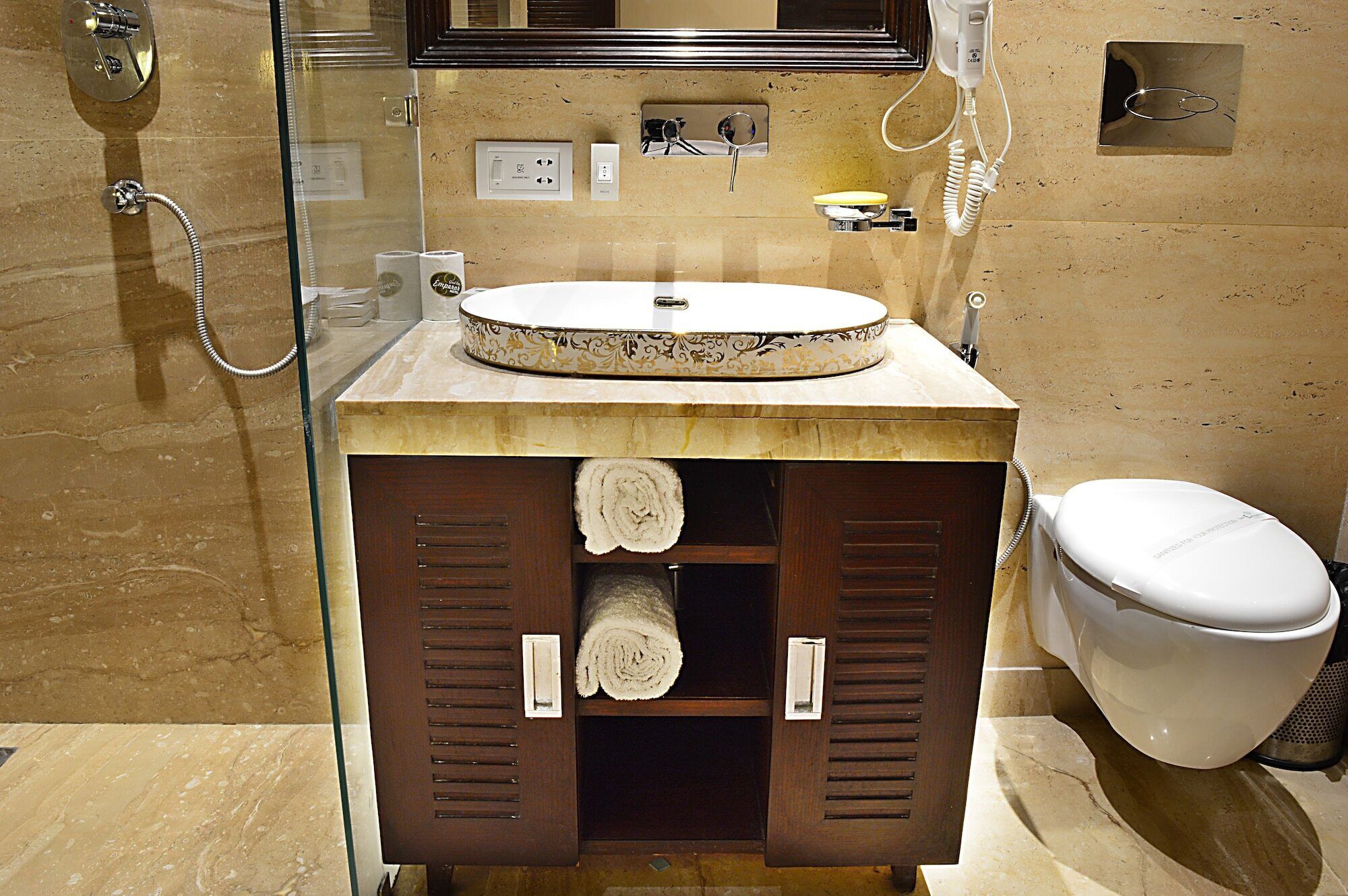 Ein Badezimmer mit einem runden Waschbecken, Toilette und Dusche.