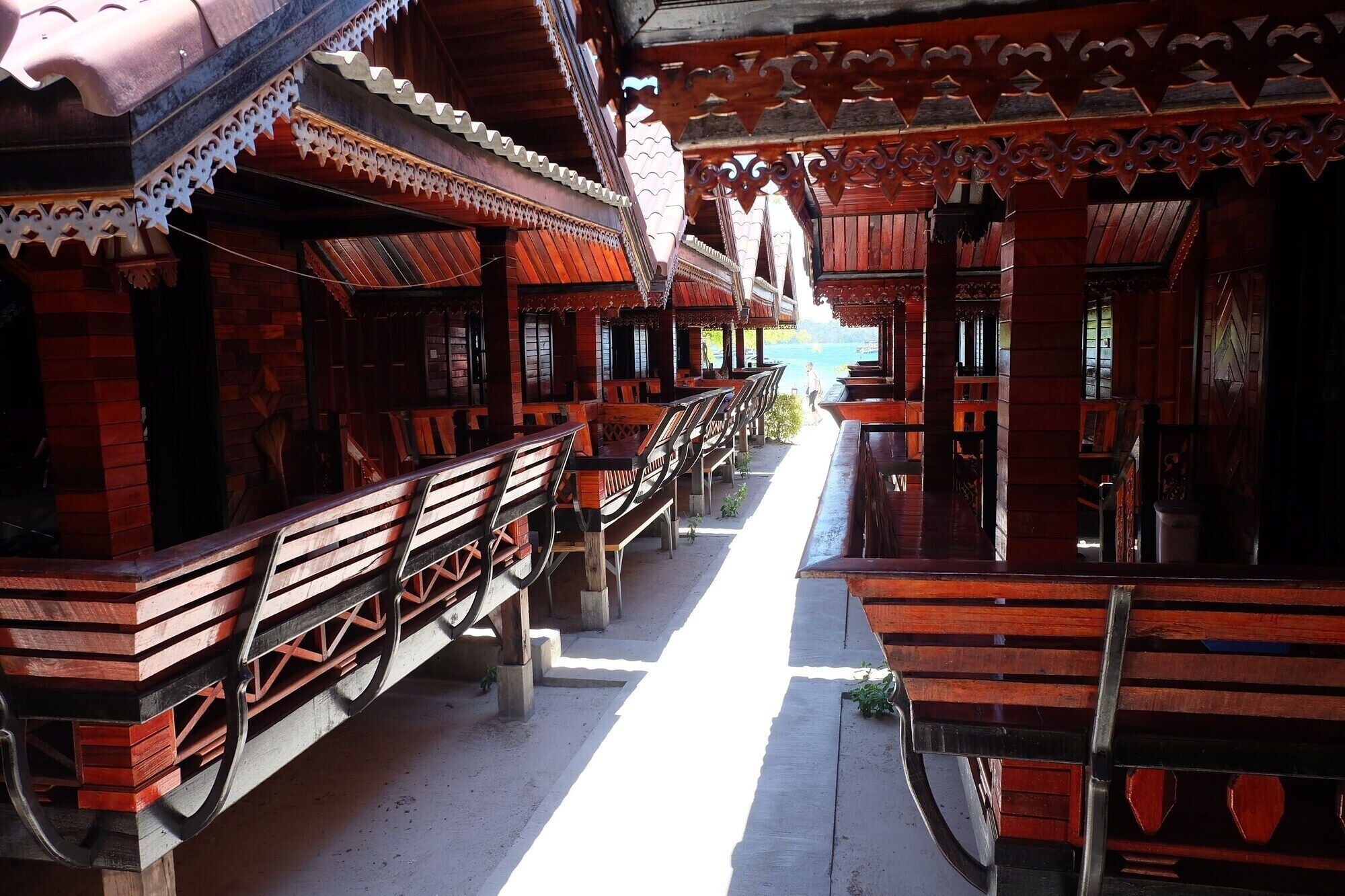 A traditional wooden structure with benches and a pathway.