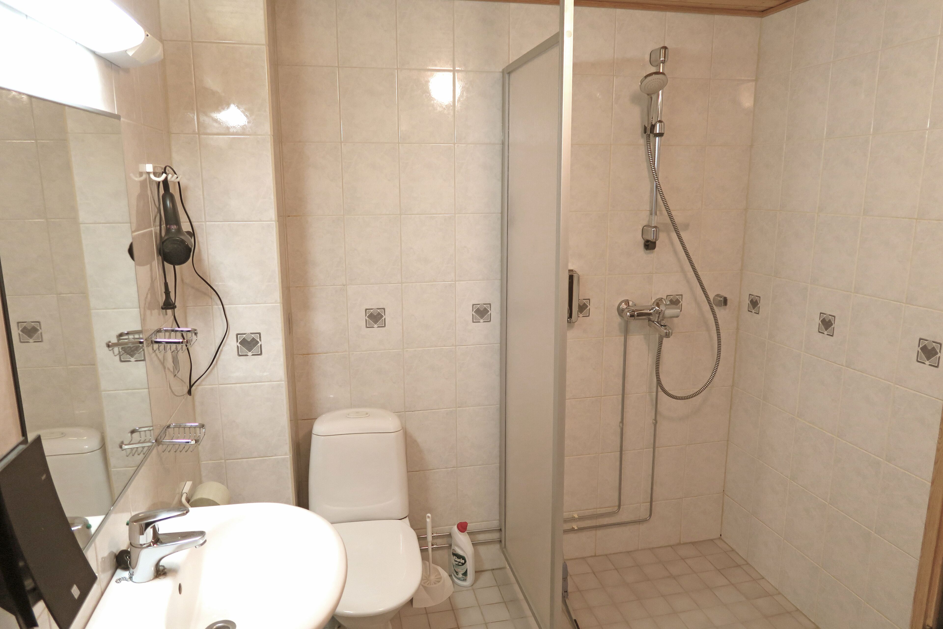 A bathroom with a toilet, sink, and shower.