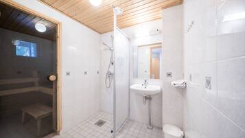 A modern bathroom with a wooden ceiling, a glass-enclosed shower, a white sink, and a toilet.