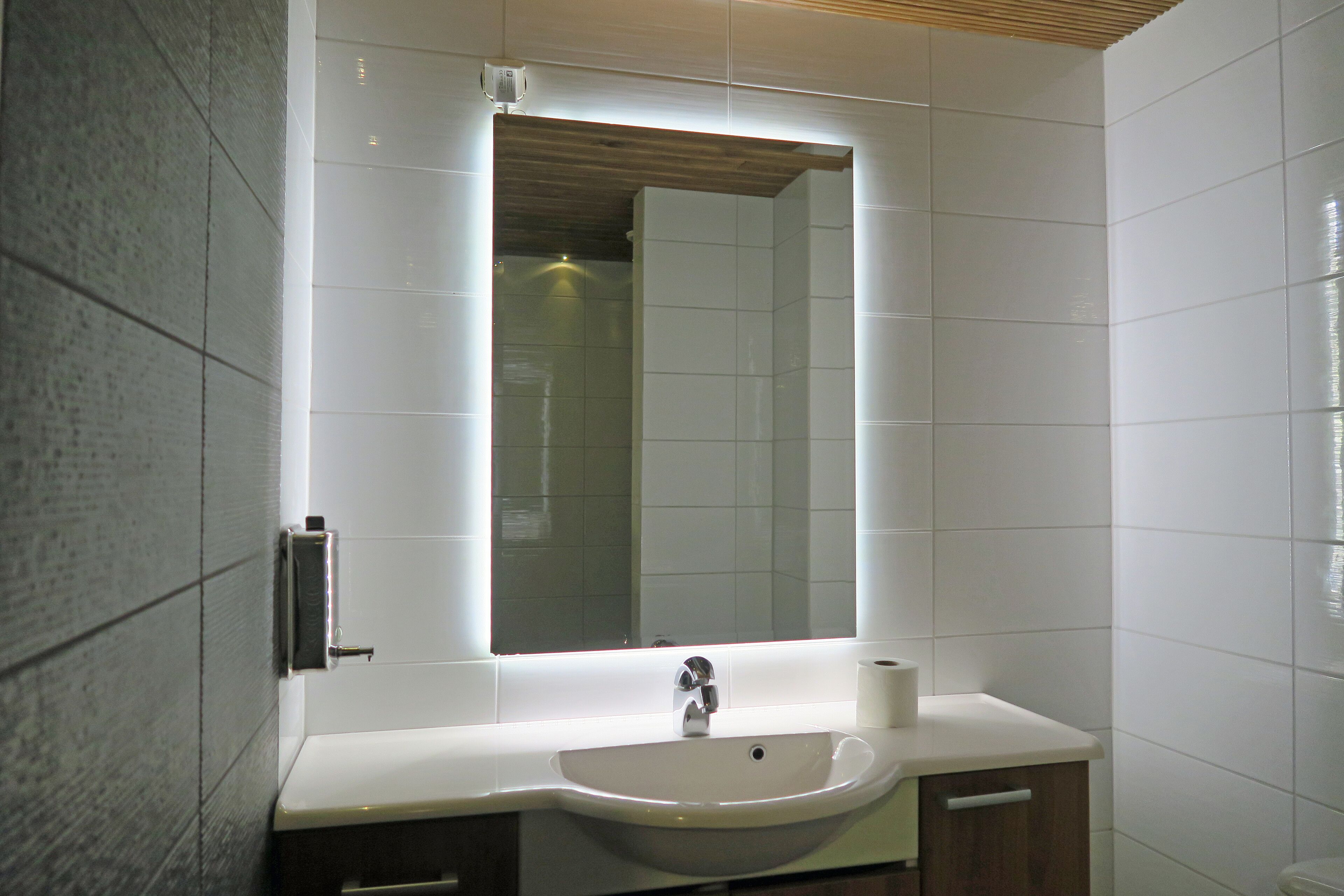 A bathroom with a white sink, a mirror, and a toilet.