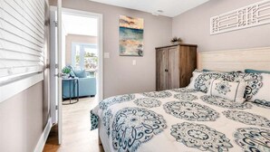 A bedroom with a bed, a ceiling fan, a cabinet, and a door leading to another room. - Reel Deal ~ Private Pool Home, 76' Dock (Marathon)