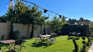An outdoor patio with tables and chairs, string lights, and a clear blue sky. - Hotel Oxford Inns & Suites (Timisoara)